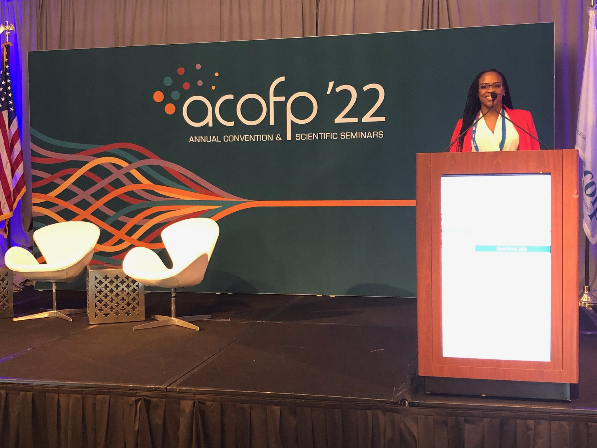 Akilah speaking at the podium at the ACOFP 2022 convention